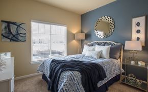 Denver apartment for rent - a bedroom with a bed and a mirror on the wall