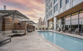Boston apartment for rent - a swimming pool on the rooftop of a building with a city in the background