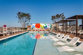 Washington apartment for rent - Rooftop pool with a mural on the wall and chairs around it.