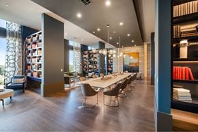 Houston apartment for rent - a dining room with a long table and chairs in a library