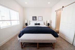Heber apartment for rent - A large bedroom with a king size bed and nightstands, complete with large windows, luxury carpet, and a barn door leading into the en suite area with an attached batroom and walk in closet space
