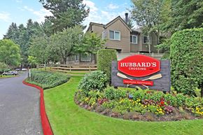 Kirkland apartment for rent - Community entrance sign with seasonal flower garden at Hubbard's Crossing Apartments, Kirkland