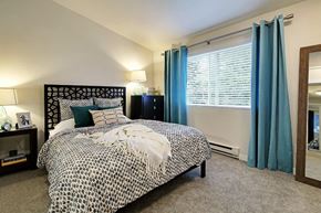 Kirkland apartment for rent - Bedroom with decorative headboard and patterned bedding at Hidden River Townhomes Apartments, Kirkland, 98034
