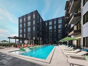 Austin apartment for rent - a large swimming pool with lounge chairs in front of a building