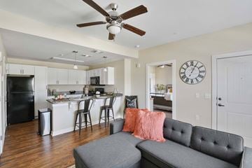 Killeen apartment for rent - A living room with a grey couch and a ceiling fan.
