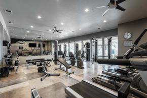 Lakewood apartment for rent - a gym with weights and cardio machines and a clock