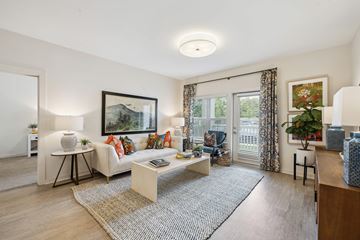 Ladson apartment for rent - A living room with a white sofa, a coffee table, and a painting on the wall.