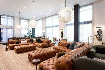 North Hollywood apartment for rent - A living room with a large sectional sofa and a long row of tufted ottomans.