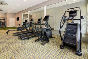 Huntersville apartment for rent - A gym with treadmills, elliptical machines, and a stair climber.