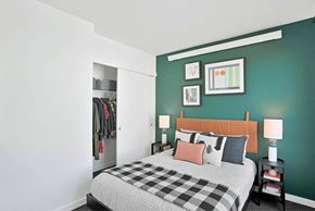 Portland apartment for rent - A bedroom with a bed, nightstand, and a wall-mounted closet.