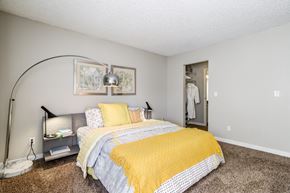 Redmond apartment for rent - A bedroom with a bed and a yellow blanket.