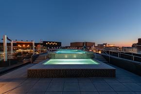 Arlington apartment for rent - A pool on a rooftop with lights on in the background.