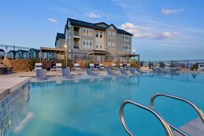 Lakewood apartment for rent - A large swimming pool in front of a multi-story building.