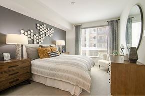 San Diego apartment for rent - A bedroom with a large bed and a mirror on the wall.
