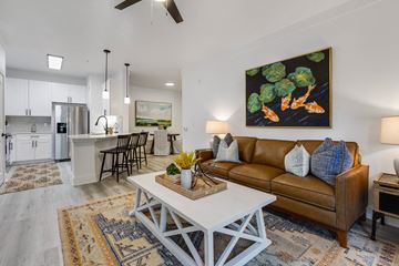 Charleston apartment for rent - A living room with a brown couch and a painting of broccoli on the wall.