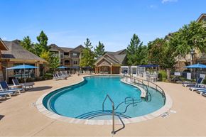 Charlotte apartment for rent - luxury apartments in Charlotte NC with In-Unit Washer and Dryer - The Banks at Rivergate - A large outdoor swimming pool surrounded by lounge chairs and umbrellas.