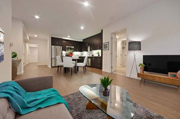 Los Angeles apartment for rent - A modern living room with a grey couch and a glass coffee table.