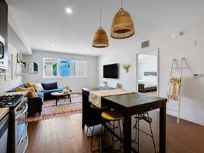 Los Angeles apartment for rent - A modern kitchen with a black countertop and a stove top oven.