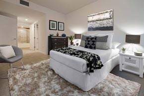 Los Angeles apartment for rent - A bedroom with a white bed and a grey chair.