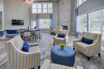 Durham apartment for rent - A living room with striped chairs and a round ottoman.