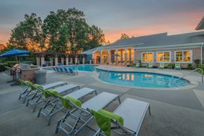 Durham apartment for rent - A poolside area with sun loungers and a building in the background.
