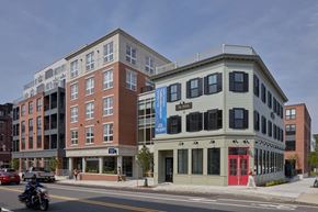 Beverly apartment for rent - A motorcycle is on the road in front of a building with a red door.