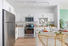 Beverly apartment for rent - A modern kitchen with a stainless steel refrigerator and a dining table set for a meal.