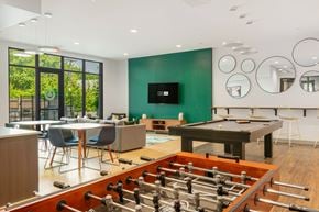 Beverly apartment for rent - A foosball table is in the middle of a room with a pool table and a television.