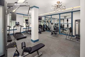 Brookhaven apartment for rent - A gym with a variety of equipment including treadmills, weights, and benches.
