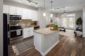 Brookhaven apartment for rent - A kitchen with white cabinets and a wooden island.