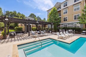 Asheville apartment for rent - A large outdoor swimming pool with a slide and sun loungers.