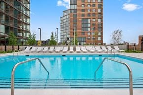 Chicago apartment for rent - A swimming pool with a metal railing in front of a building.