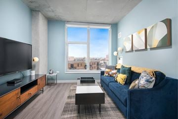 Chicago apartment for rent - A living room with a blue couch and a television.