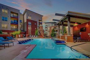Denver apartment for rent - A swimming pool surrounded by lounge chairs and apartment buildings.
