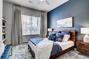 Denver apartment for rent - A bedroom with a large bed and a window with curtains.