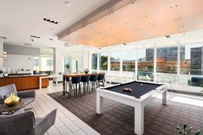 San Francisco apartment for rent - A billiard table is in the middle of a room with a kitchen area and a balcony.