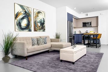 Glendale apartment for rent - A modern living room with a couch, a coffee table, and two abstract paintings on the wall.