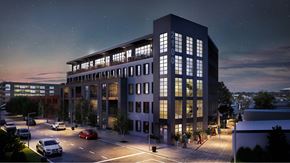 Richmond apartment for rent - A modern building with a glass facade is lit up at night.