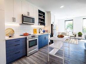 Richmond apartment for rent - A modern kitchen with blue cabinets and a white island.