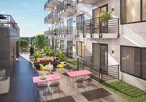 Richmond apartment for rent - A patio with a table and chairs is surrounded by apartment buildings.