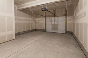 Fort Collins apartment for rent - A spacious garage with a closed white door and a ceiling light at Bloom Rental Living apartments in Fort Collins, CO.