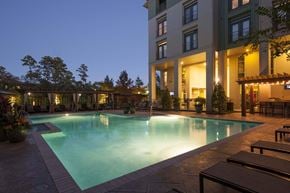 Spring apartment for rent - A large swimming pool in front of a building at night.
