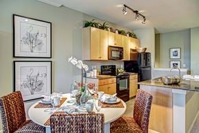 Spring apartment for rent - A kitchen with a table set for two with chairs around it.