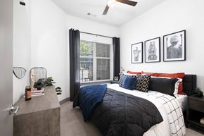 Denver apartment for rent - A bedroom with a bed, a nightstand, and a window with curtains.