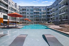 Denver apartment for rent - A large swimming pool with a metal diving board in the middle of it.
