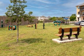 Frisco apartment for rent - A park with a bench, a tree, and a playground.