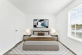Altamonte Springs apartment for rent - A bedroom with a large bed and a painting above it.