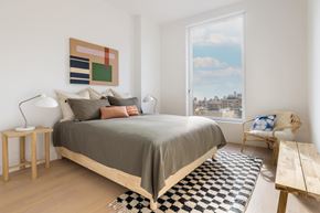 New York apartment for rent - A bedroom with a large bed and a view of the city.