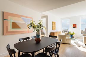 New York apartment for rent - A dining room with a table and chairs and a painting on the wall.