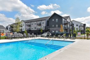 Grandville apartment for rent - Swimming pool with lounge chairs at The Commons at Rivertown Grandville Apartments in MI.